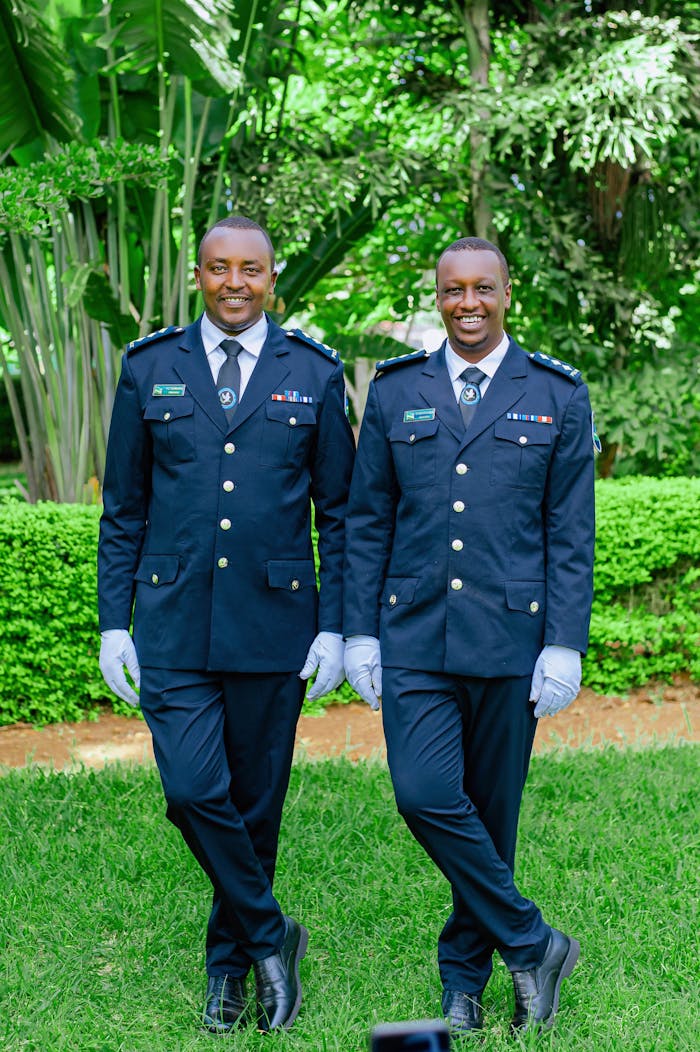 Two police officers in uniform standing outdoors on a sunny day.